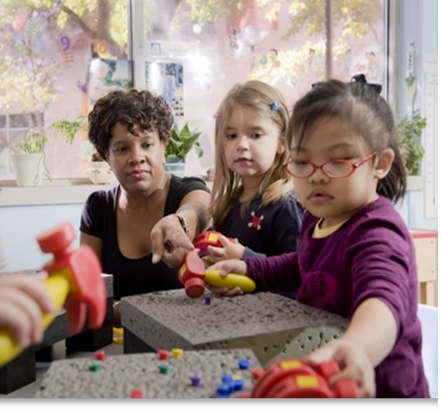 Child care provider at table with children
